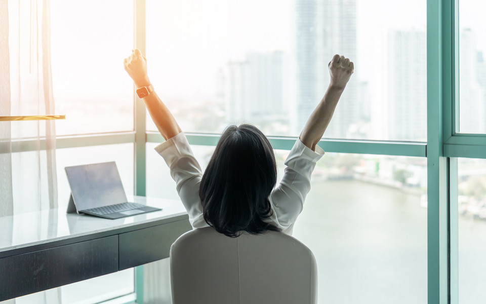 Woman successfully managing Credit Risk Scoring with arms in air