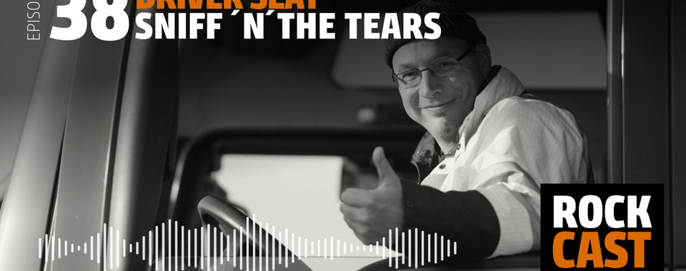 A smiling man looking out of a truck. Overlay text reads "Episode 38 Driver Seat Sniff ’N’ The Tears."