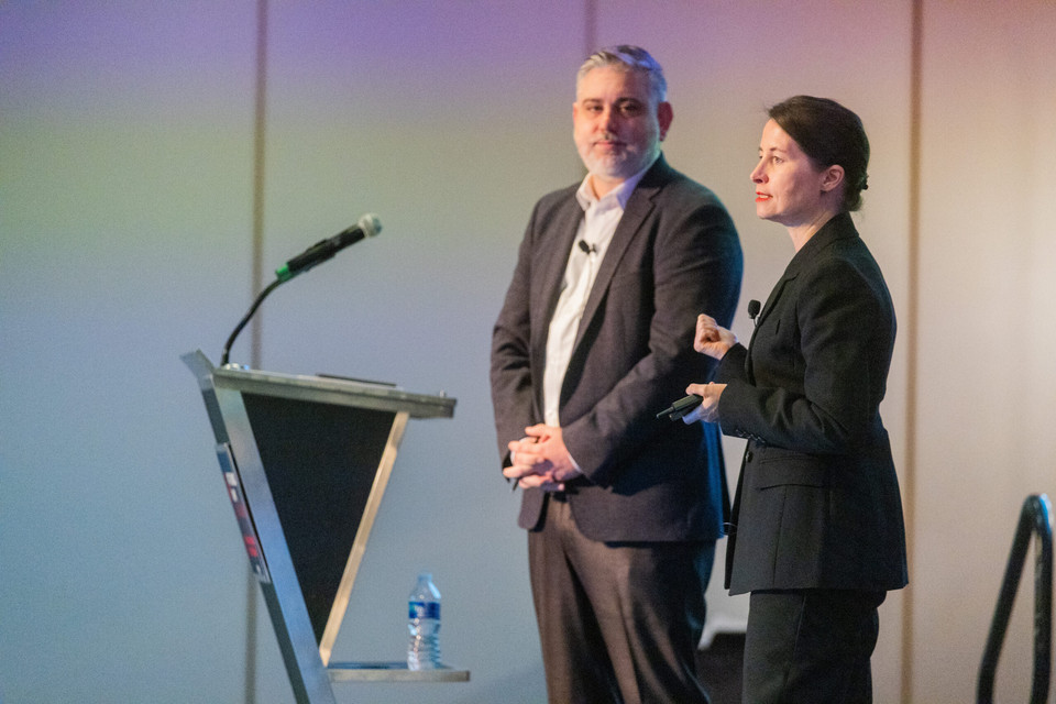 Loren Mathis (l) and Dr. Eva Savelsberg (r) on stage giving a keynote on the similarities and differences of the container terminal and aviation industries